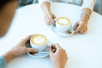 people holding cups of coffee on a table